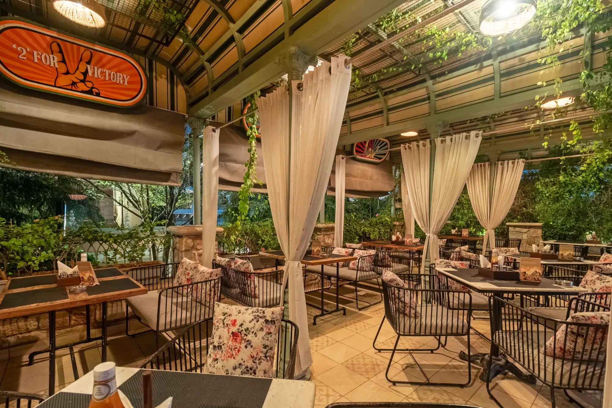 The pergola terrace — linen drapes and floral cushions