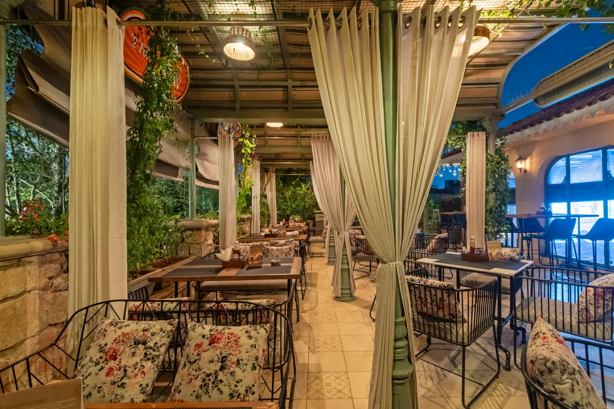 The terrace, framed in white drapes and green vines